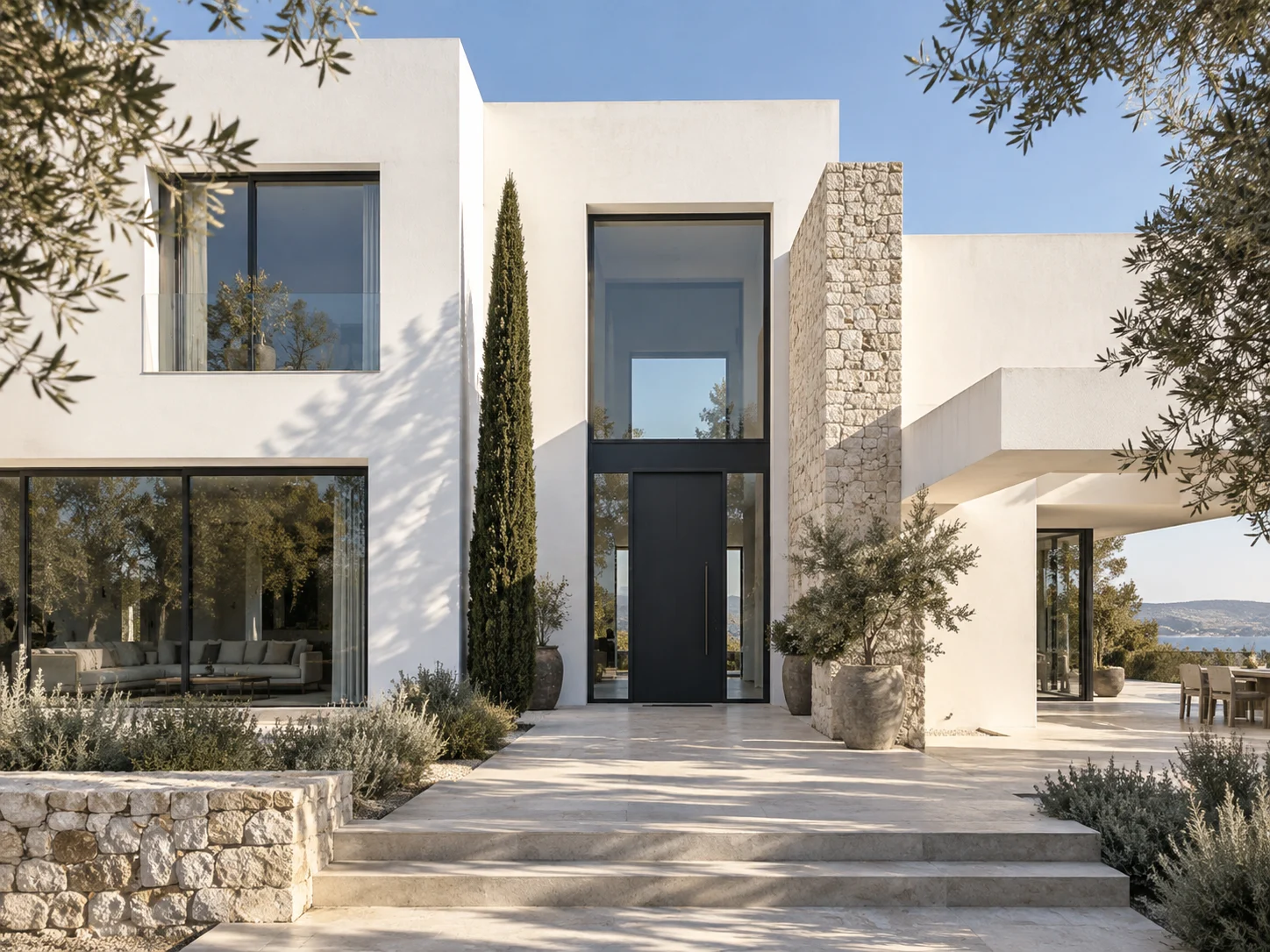 Vivienda blanca con patio, piedra y vegetación